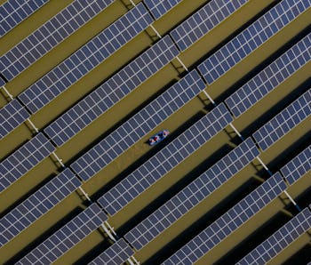 HAI AN, CHINA - APRIL 06: Workers carry out maintenance on solar panels installed atop a fish pond a...