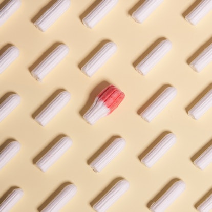 Tampons on a yellow background with one marked with red. An OB-GYN explains why the COVID vaccine ca...