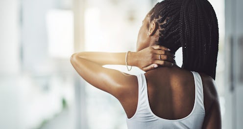 A person faces away from the camera while rubbing one hand on the back of their neck. Even though it...