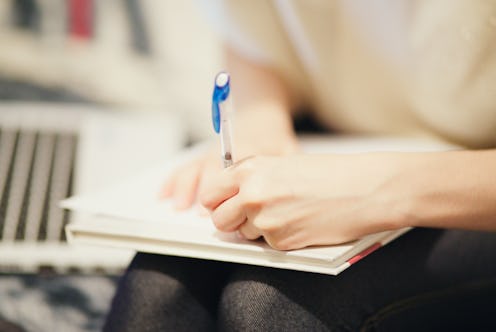woman writing in her notebook with her left hand