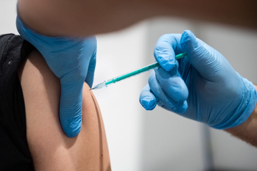 A doctor inoculates a woman with a COVID vaccine. Tingling in hands and fingers is a rare side effec...