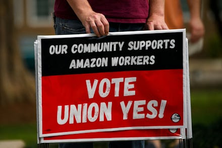 A person holds "Vote Union Yes!" signs during a protest in solidarity with Black Lives Matter, Stop ...