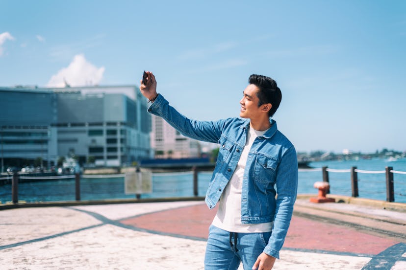 Millennial generation - Handsome Asian man taking selfie in the city