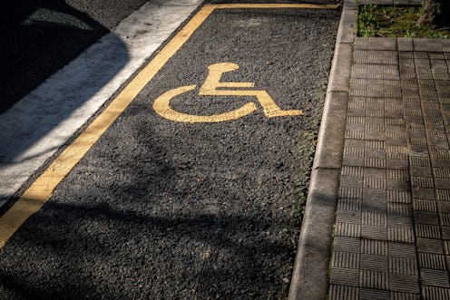 Photo of a handicapped parking lot with the dummy painted in yellow when it should be blue.