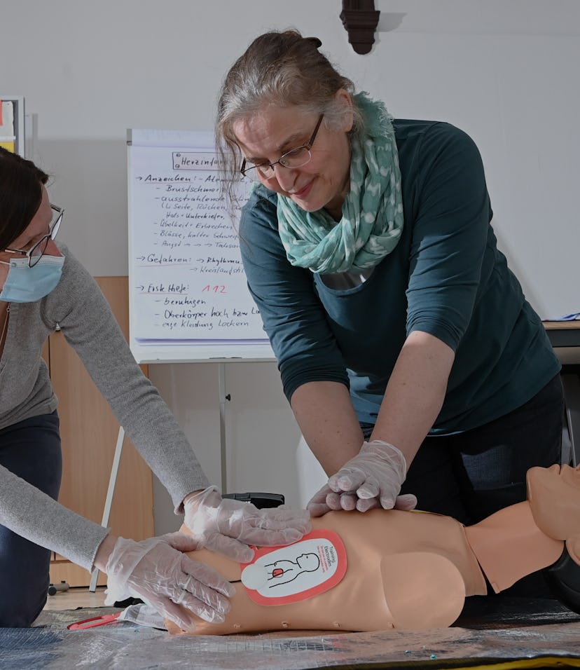 24 April 2021, Brandenburg, Falkensee: Volunteer instructor Anja Mudlagk (l) and first aid instructo...