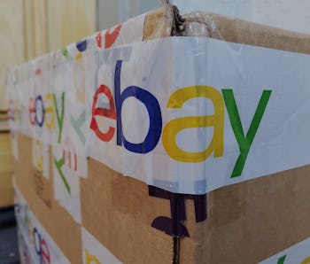 Close-up of the eBay logo featured on the packing tape securing a large cardboard shipping box in Sa...