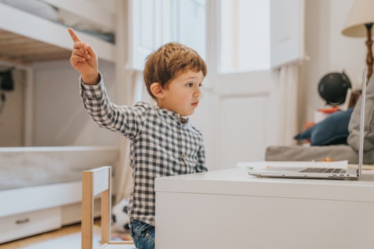 Boy attending to online school class.