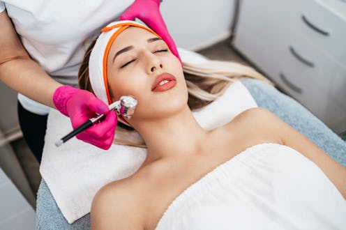 Beautiful and attractive adult woman receiving professional facial care steam beauty treatment