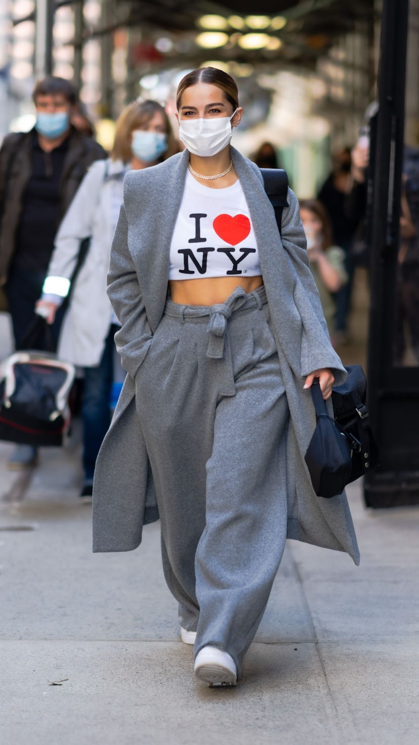 Addison Rae wearing one of her best outfits: a gray pantsuit with an NYC tourist t-shirt