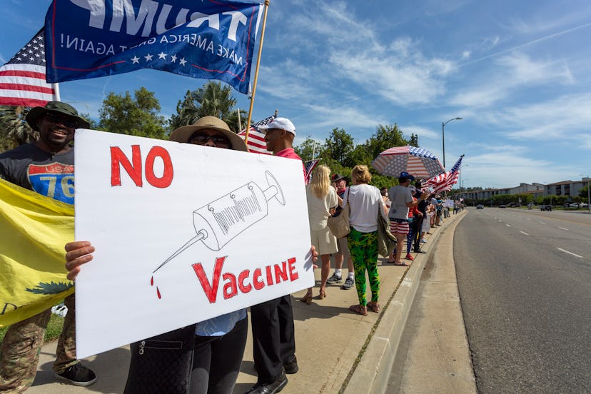 WOODLAND HILLS, CA - MAY 16: A protester holds an anti-vaccination sign as supporters of President D...