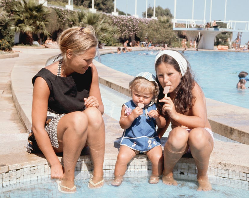 A family enjoying popsicles by the water in the 1960s.