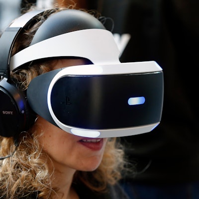 PARIS, FRANCE - FEBRUARY 24:  A woman plays a video game with a virtual reality head-mounted headset...
