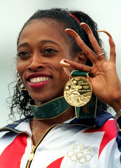 Gail Devers posing with a gold Olympic medal