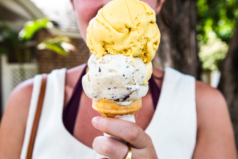 A Woman Holds Up Her Double Scoop Of Icecream