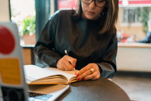 Young woman taking notes at a cafe