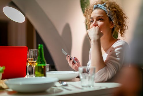 Young millennial woman sitting at the dining table, thinking about the signs her parents were emotio...