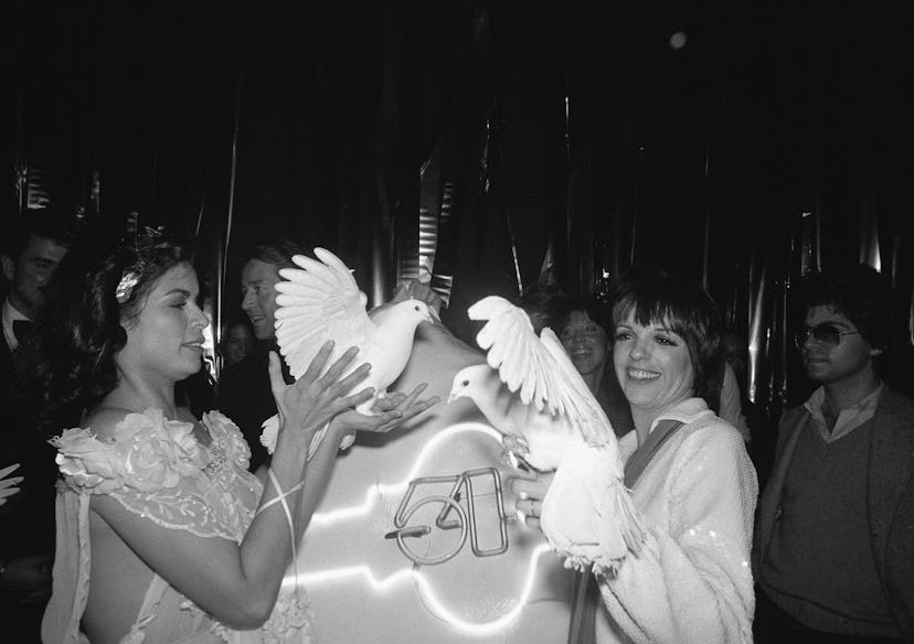 Model Bianca Jagger and singer Liza Minnelli holding white doves at the popular nightclub Studio 54.