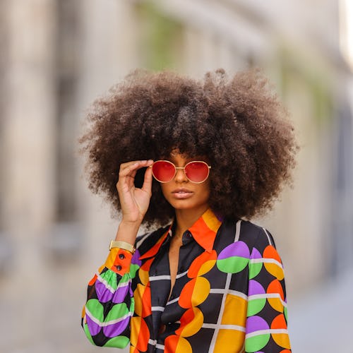 PARIS, FRANCE - MAY 03: Alicia Aylies wears red and gold Bottega Veneta sunglasses, a gold chain pen...