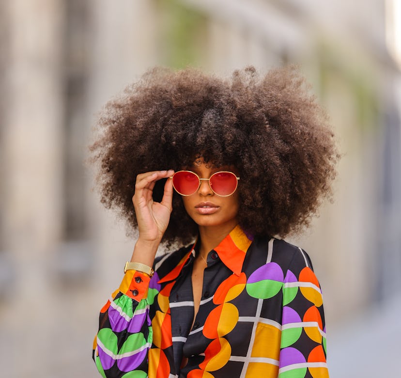 PARIS, FRANCE - MAY 03: Alicia Aylies wears red and gold Bottega Veneta sunglasses, a gold chain pen...