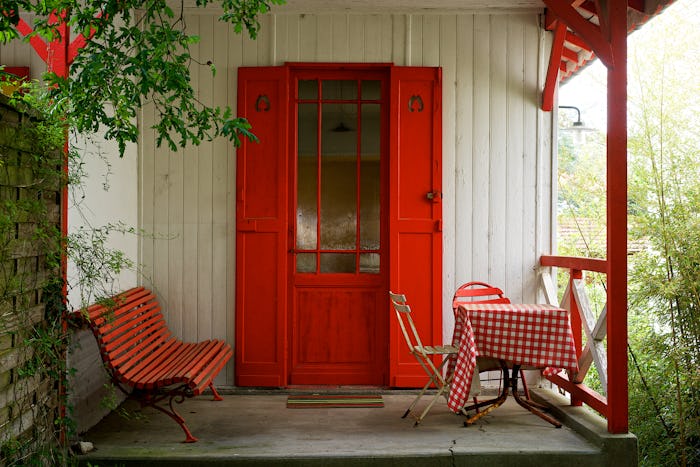 red benches and red door on small porch