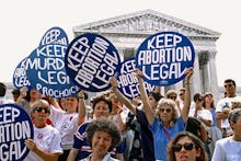 Pro-life and pro-choice demonstrators hold signs on the steps of the Supreme Court building  The pro...