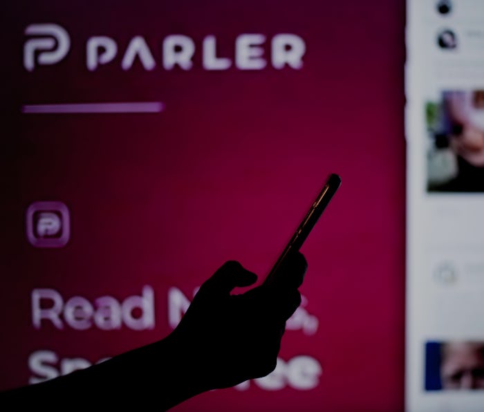 SPAIN - 2021/01/14: In this photo illustration a Parler website is seen behind a cell phone.
The 'fr...