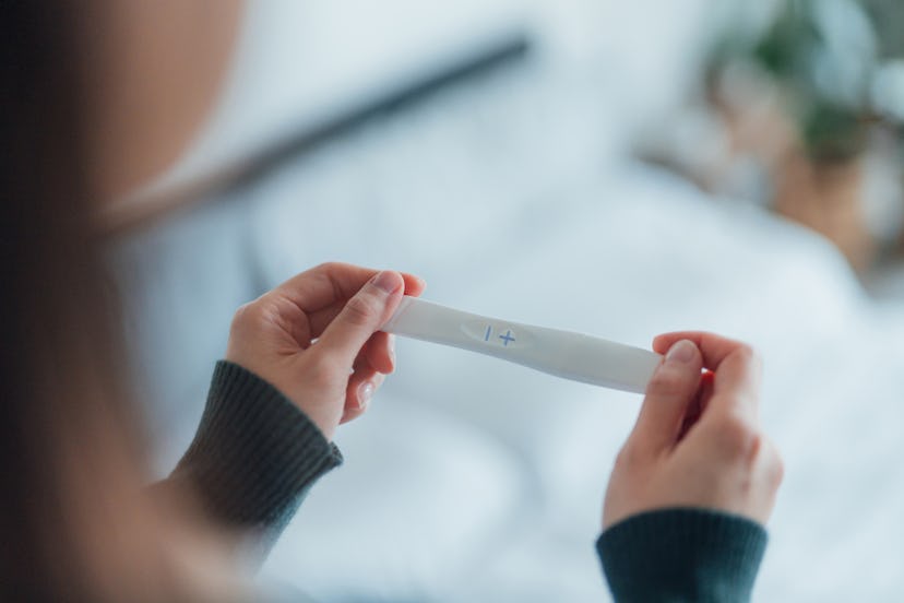Close-up shot of unrecognisable Asian woman holding a pregnancy test kit and waiting for the result ...