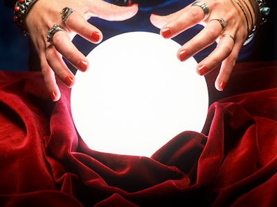 close up on female gypsy hands on a glowing crystal ball