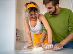 A happy couple kneads some dough to make Frog Bread from TikTok at home.