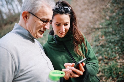 Father and daughter spending time together outdoors, hiking in the nature, watching stuff at the sma...