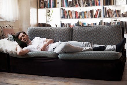 Man sleeping on sofa in cozy loft apartment