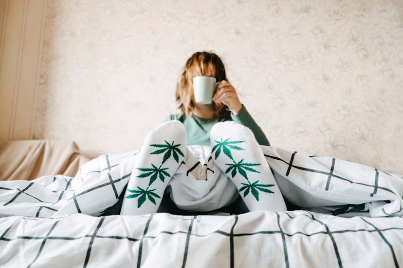 A woman drinks coffee in bed wearing sweatpants with pot leaves on it. Here are things that can happ...