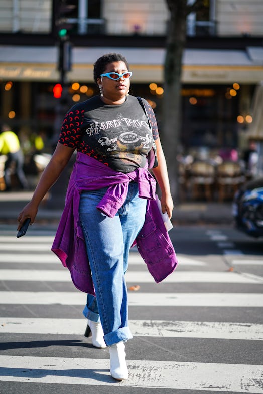 PARIS, FRANCE - SEPTEMBER 28: A guest wears blue sunglasses, a "Hard Rock Cafe" t-shirt, a purple ja...
