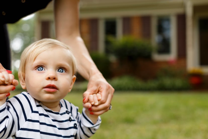 a baby holding her mother's hands