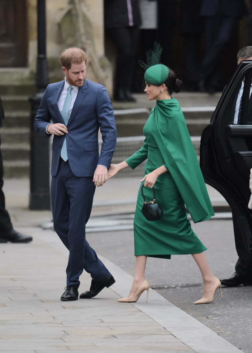 Meghan Markle reaches for Prince Harry's hand.