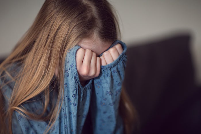 a young girl with her head in her hands