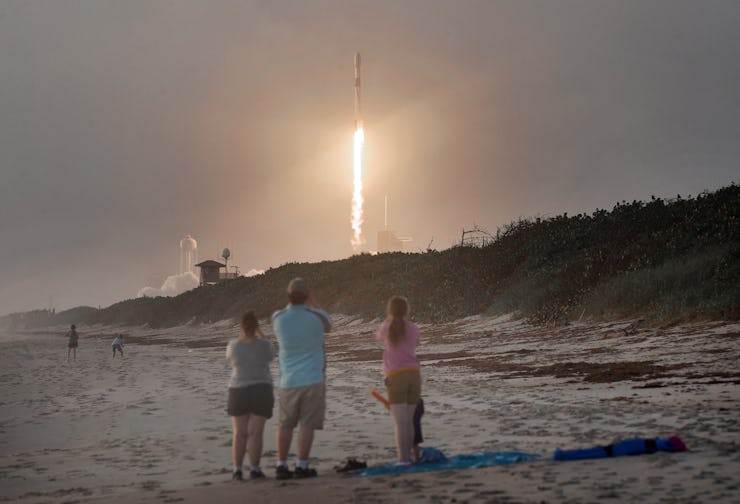 Spectators watch from Canaveral National Seashore as a SpaceX Falcon 9 rocket carrying 60 Starlink s...