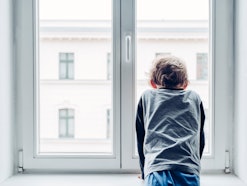 boy looking out the window alone