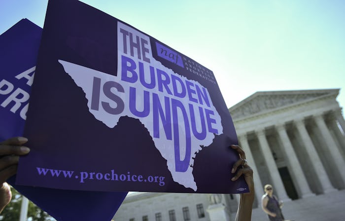 An abortion rights activist holds placards outside of the US Supreme Court before the Court struck d...