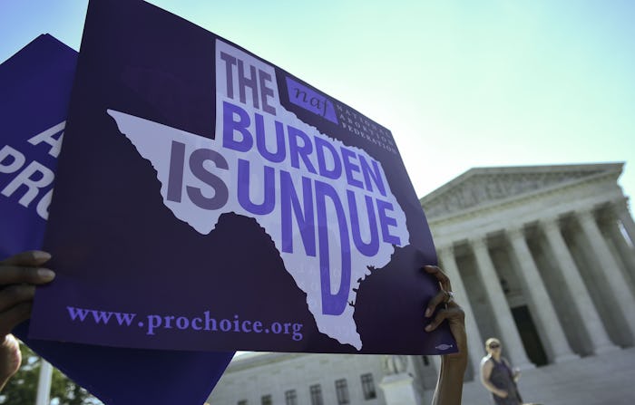 An abortion rights activist holds placards outside of the US Supreme Court before the Court struck d...