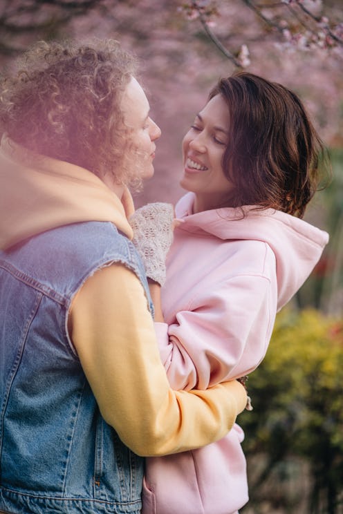 Two women hug in a cherry blossom garden. How long does it take to love someone? Experts explain why...