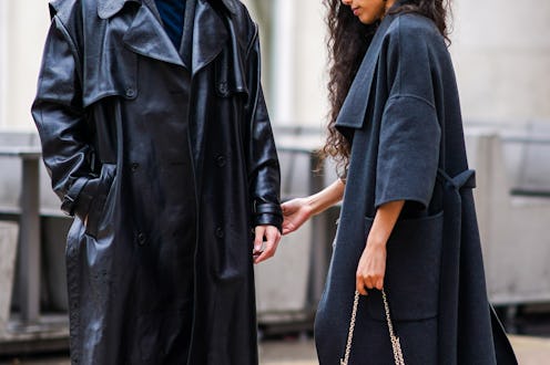 PARIS, FRANCE - FEBRUARY 29: A guest wears a gray coat and holds the hand of another guest who wears...