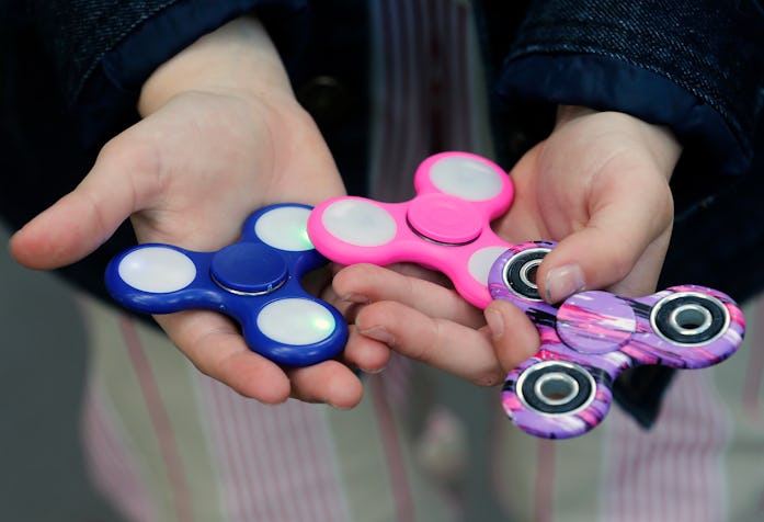 PARIS, FRANCE - MAY 20:  In this photo illustration, a child shows a "Hand Spinner" on May 20, 2017 ...