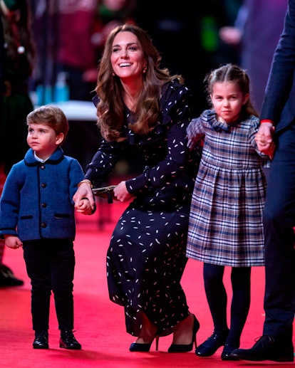 Britain's Catherine, Duchess of Cambridge (C), holds the hand of her son, Britain's Prince Louis of ...