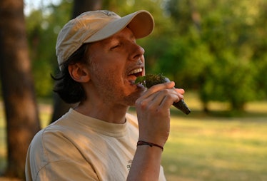 A man eats a fried cicada sushi roll prepared by Chef Bun Lai at Fort Totten Park in Washington, DC ...