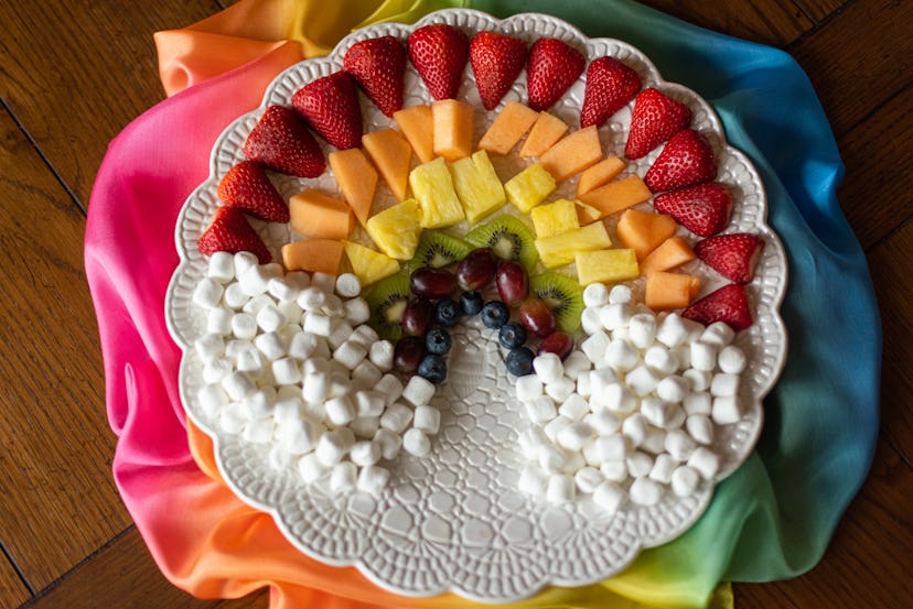Fruit and marshmallows arranged in a rainbow.