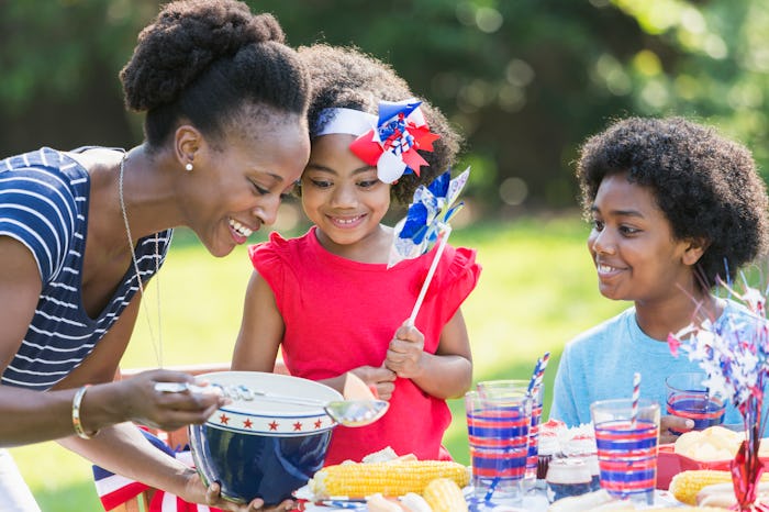 An African American mother with two mixed race children celebrating an American patriotic holiday, p...