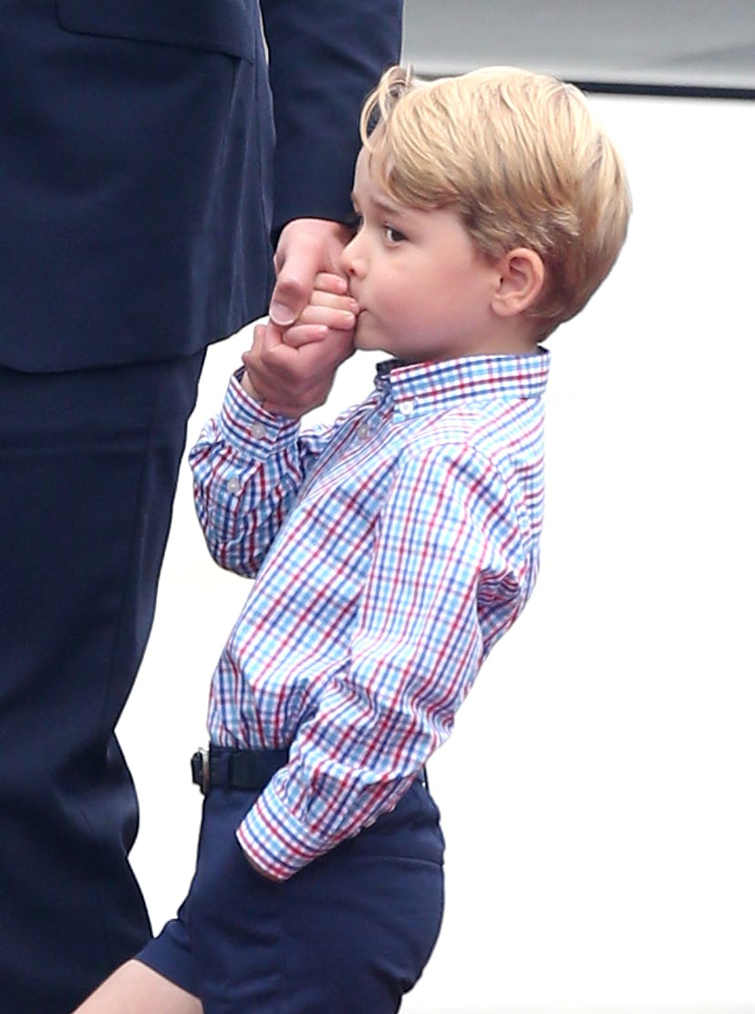 Prince George kisses his dad's hand.