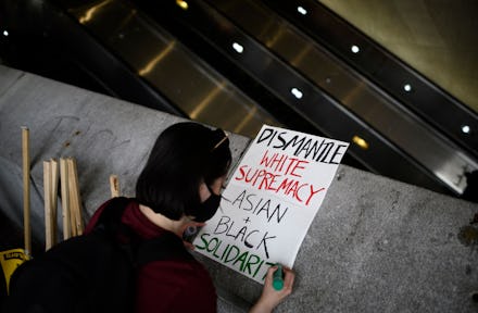 A woman makes a sign before an 'Anti Asian Hate' rally in Chinatown in Washington, DC on March 27, 2...