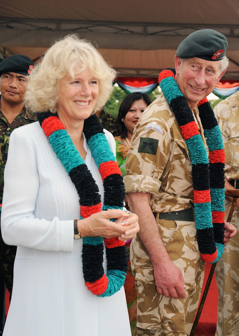 Prince Charles and Camilla Parker Bowles wear matching garlands.